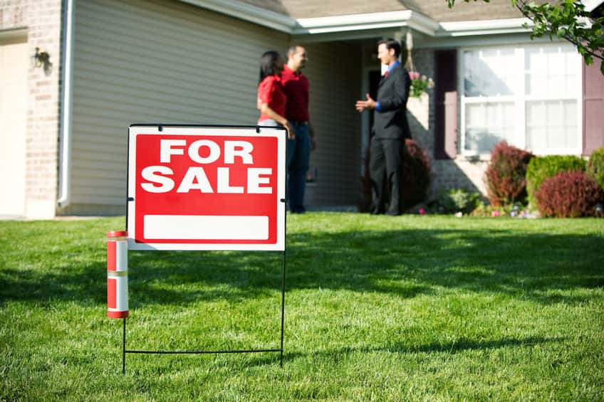 a for sale sign in front of a house