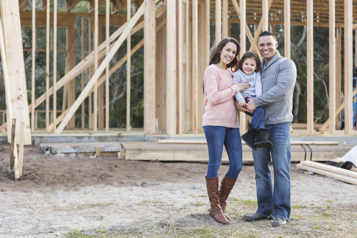 a family standing in front of a house under construction