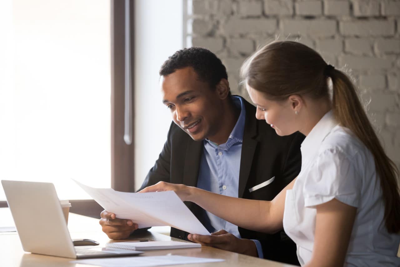 a man and a woman looking at a piece of paper