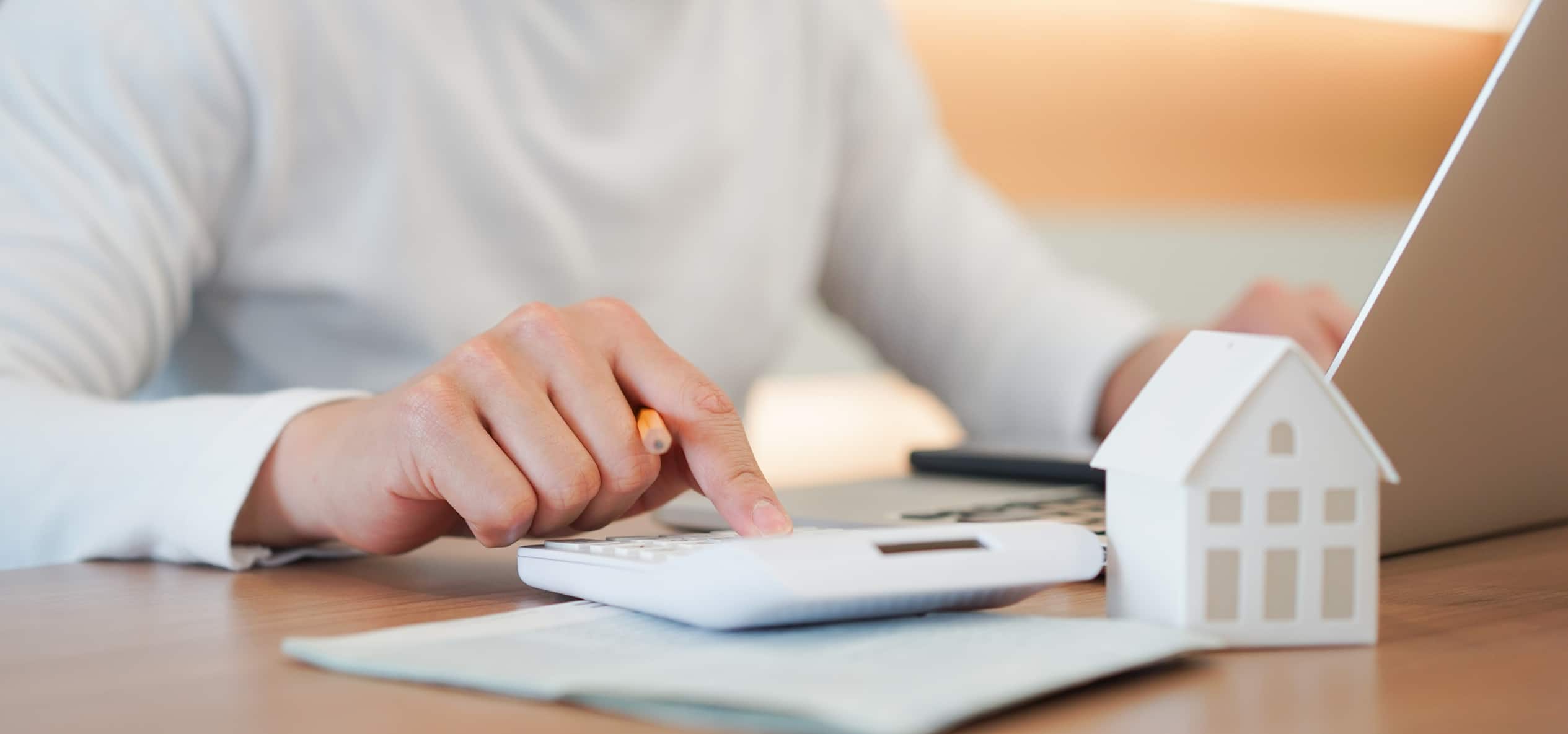 Close up young man hand press on calculator to check and summary expense of home loan mortgage