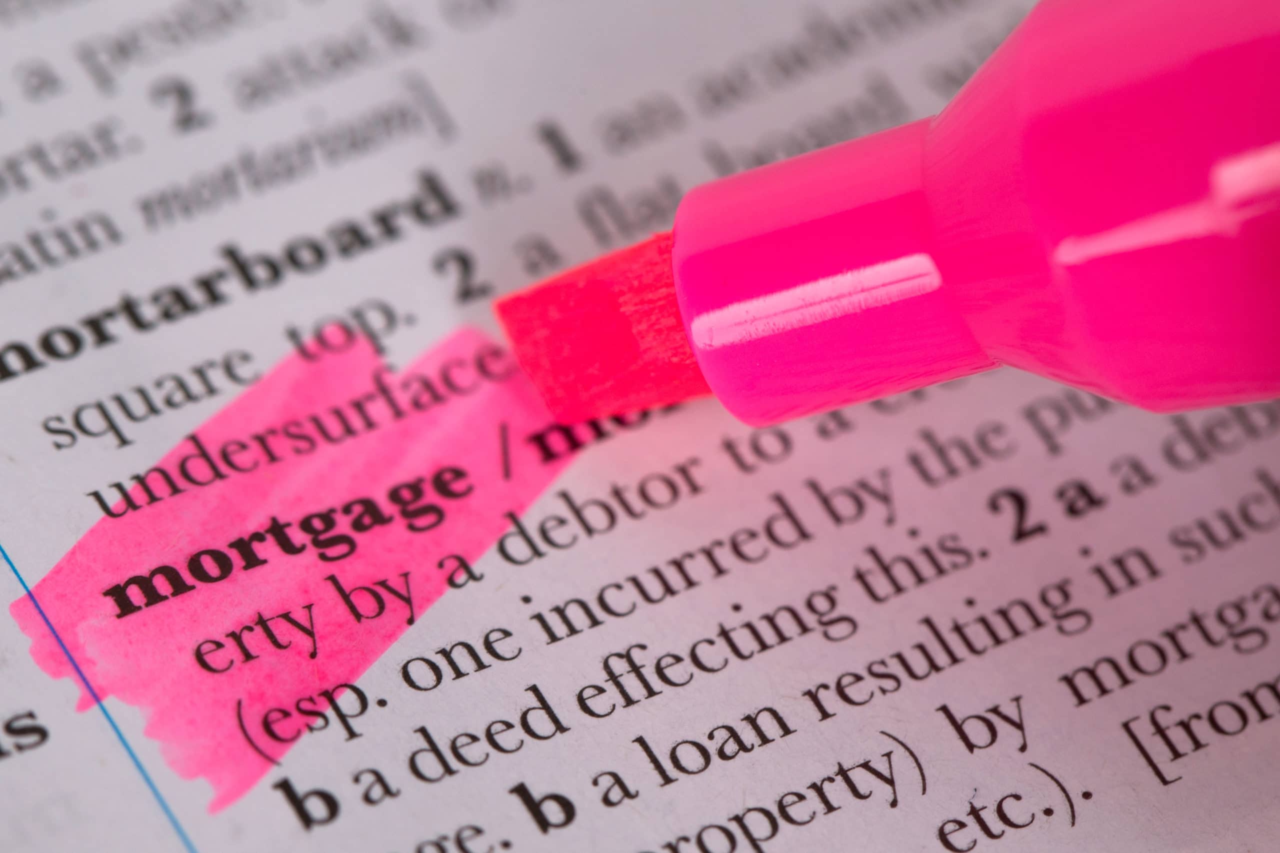 a pink marker is highlighting the word mortgage in a dictionary