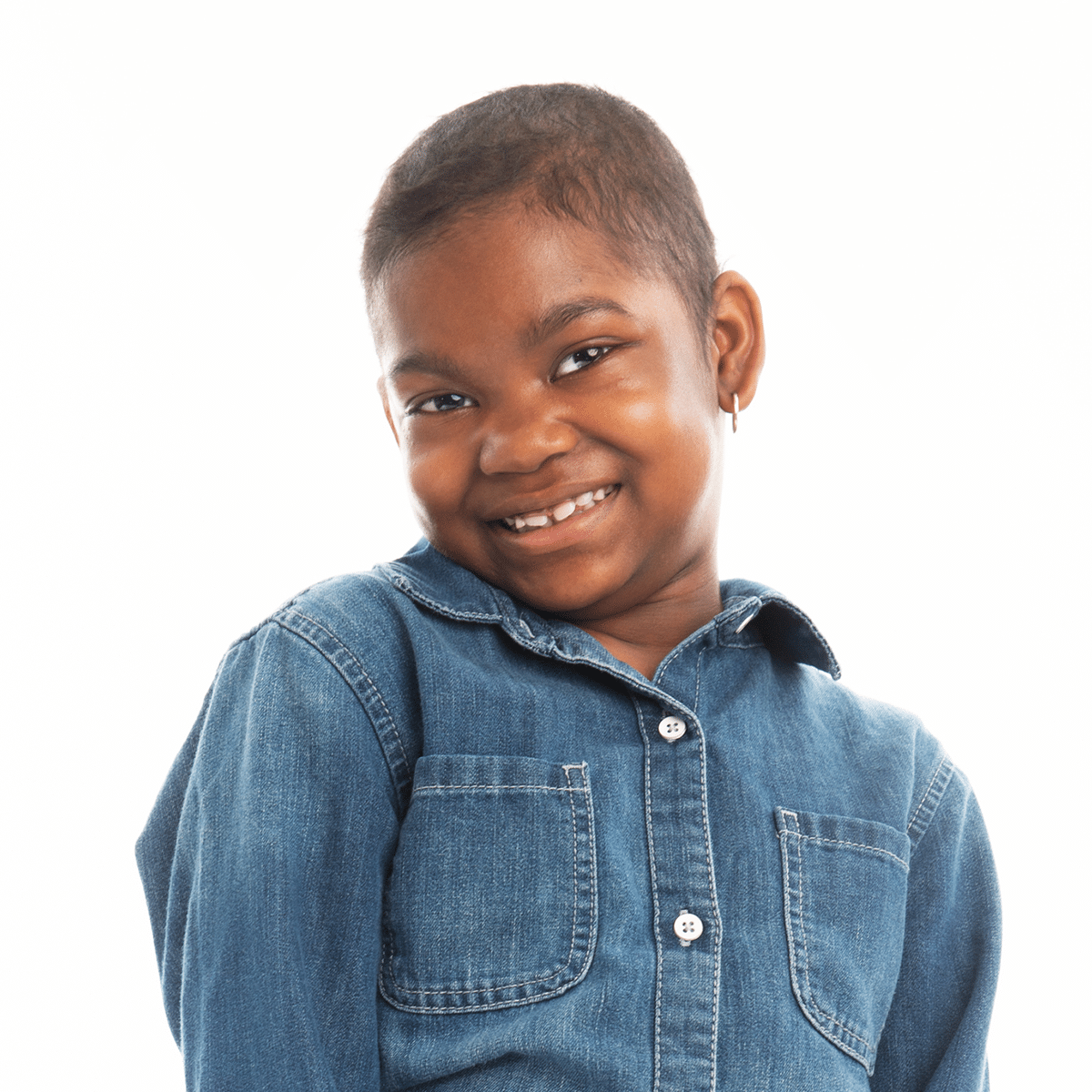 a young girl wearing a blue denim shirt smiles for the camera