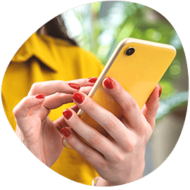 a woman with red nails holding a yellow cell phone