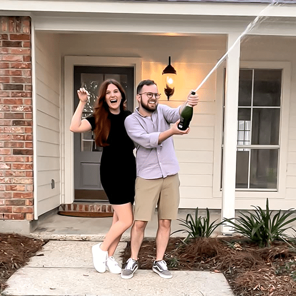 couple celebrating popping champagne bottle